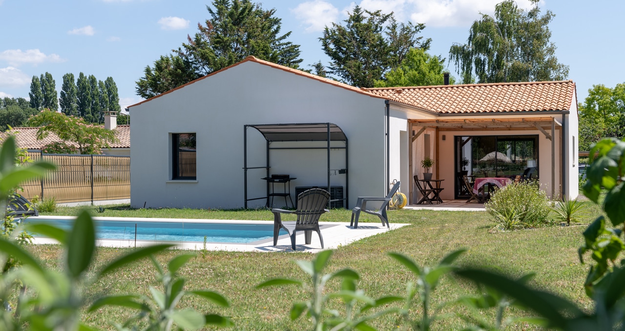 Vue extérieure d’une maison neuve en Loire-Atlantique avec tuiles Romane et enduit blanc, 3 chambres et 2 salles de bain.