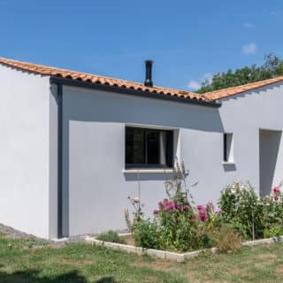Découvrez une maison traditionnelle de 97 m² en Loire-Atlantique, toit en tuiles Romane et menuiseries aluminium gris anthracite.