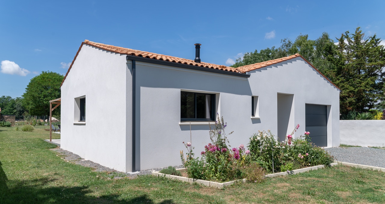Découvrez une maison traditionnelle de 97 m² en Loire-Atlantique, toit en tuiles Romane et menuiseries aluminium gris anthracite.