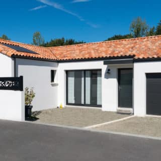 Maison en L de 121 m² à Montbert – façade avant avec enduit blanc et menuiseries noires