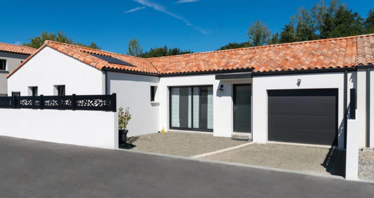 Maison en L de 121 m² à Montbert – façade avant avec enduit blanc et menuiseries noires