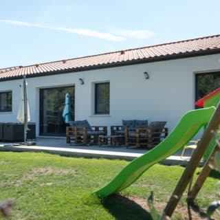 Maison en L de 121 m² à Montbert – vue côté jardin avec cuisine ouverte et espace extérieur