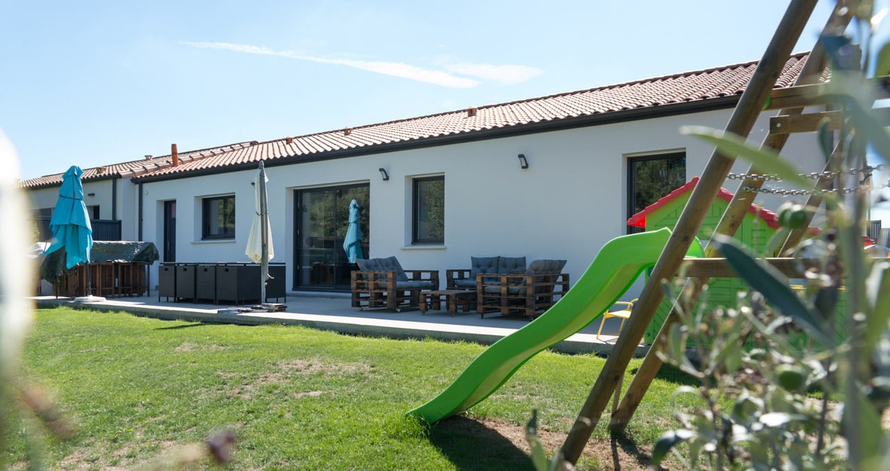 Maison en L de 121 m² à Montbert – vue côté jardin avec cuisine ouverte et espace extérieur