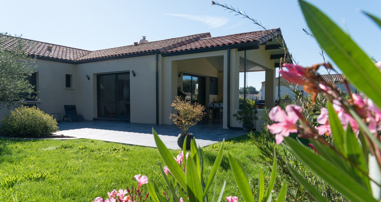 Vue extérieure sur maison neuve 117m² – porche prolongeant la pièce de vie côté jardin